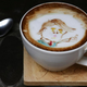 A cup of coffee with latte art in the image of Donald Trump